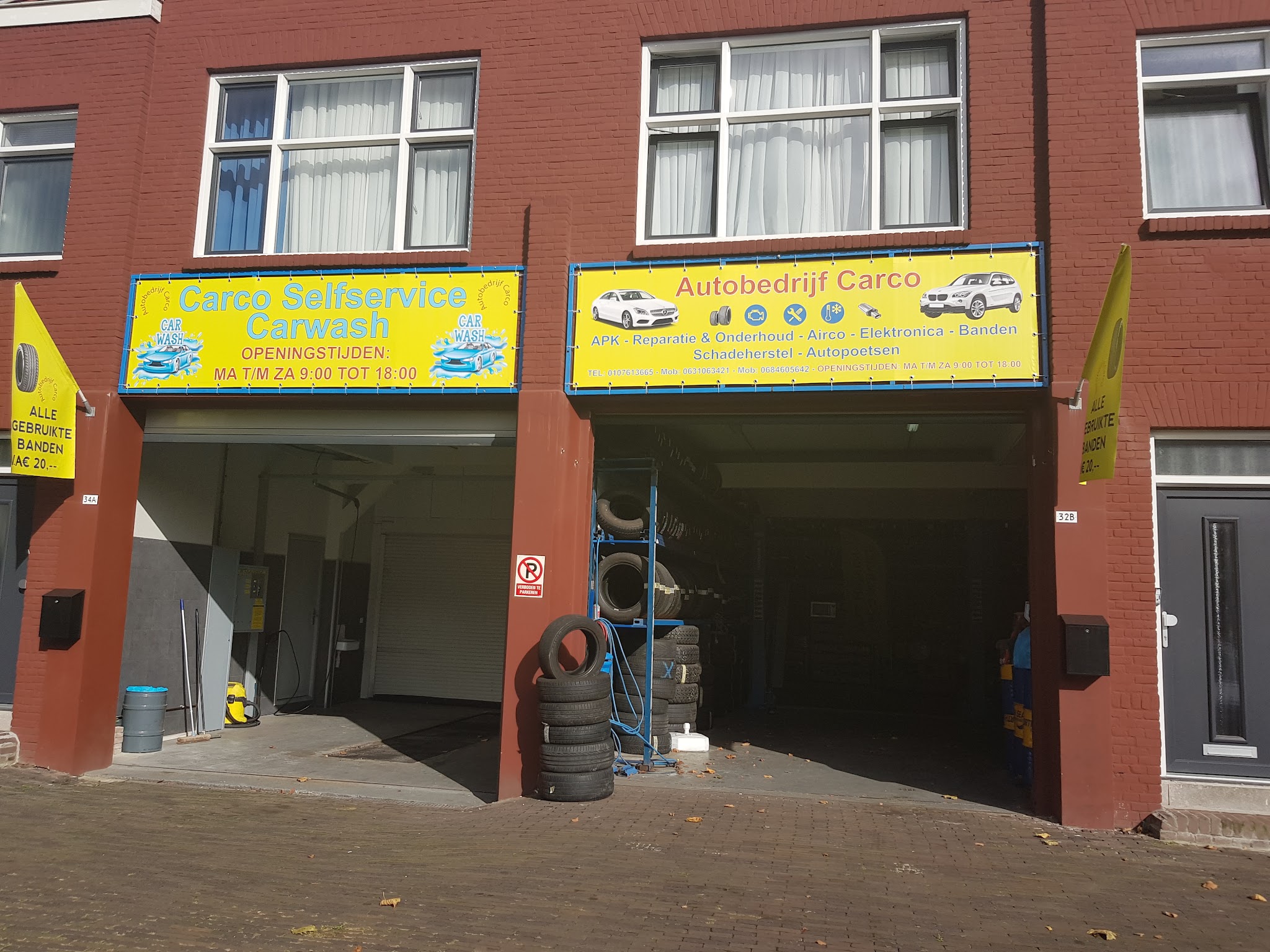 Gevel van Autobedrijf Carco met de gele borden boven de garagedeuren